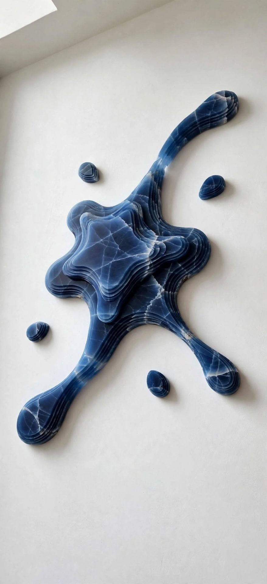 Deep Well — a blue onyx splash sculpture with layered contours and scattered droplets.